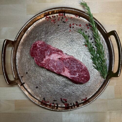 A ribeye on a tray of garnishment