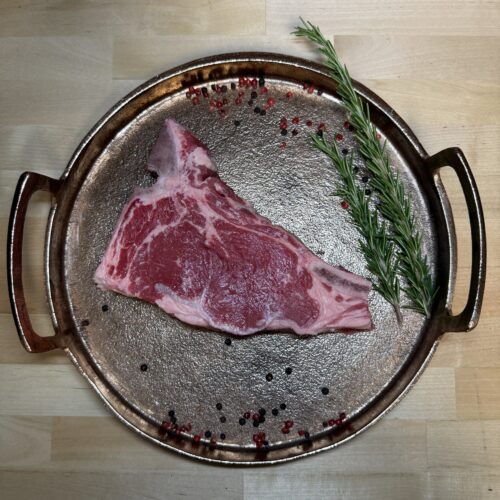 A T-Bone steak on a tray of garnishment