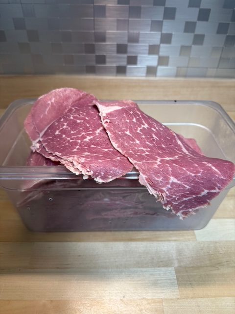 a bin full of corned beef deli meats