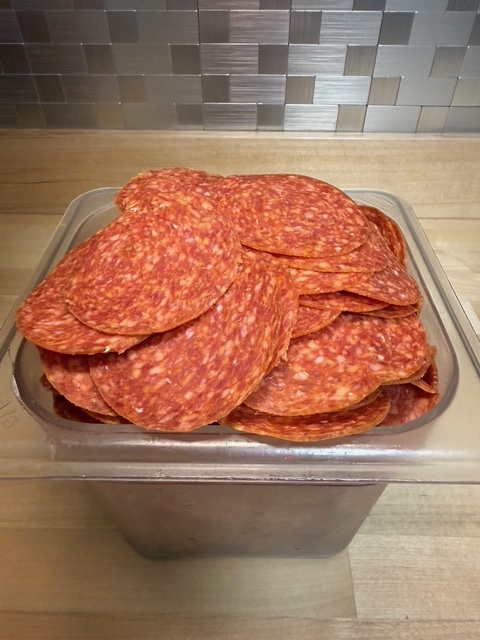 A bin full of gourmet pepperoni deli meats