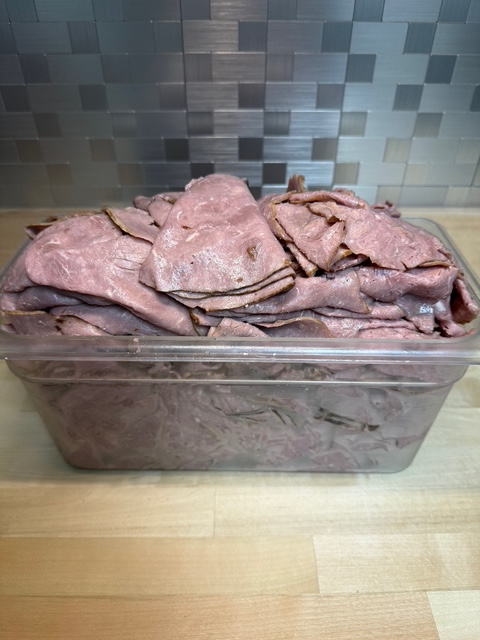 A bin full of sliced roast beef