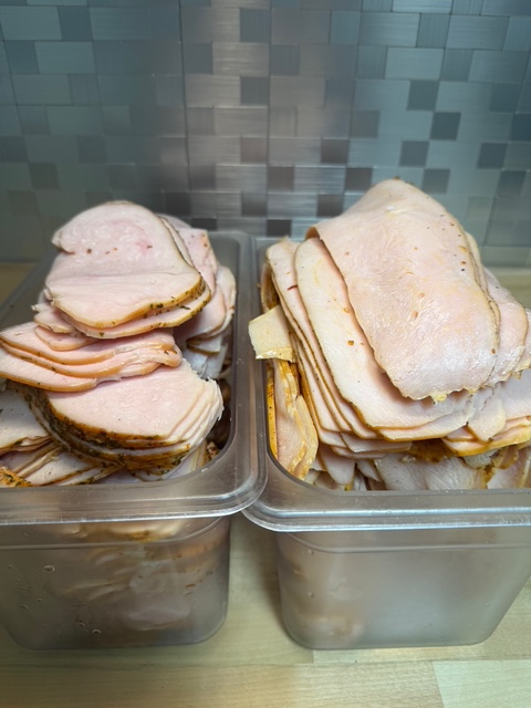 two bins of various turkey deli meats