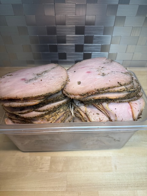 A bin of sliced pepper turkey deli meat