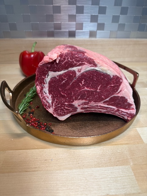 A four pound bone in rib roast on a tray of garnishments