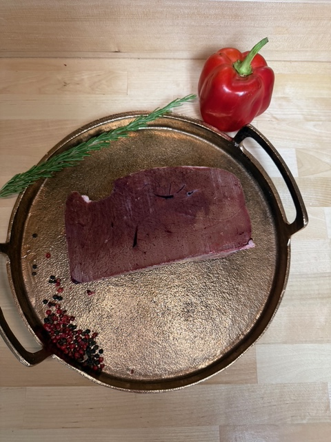 A slice of frozen beef liver on a tray of garnishment