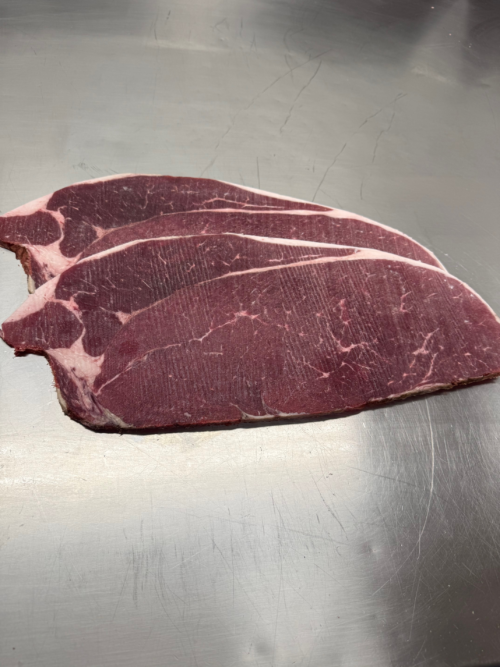 Two slices quarter inch thick frozen top round beef steak meant for Rouladen dishes.