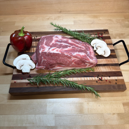 Boneless Pork Shoulder on a board of garnisments