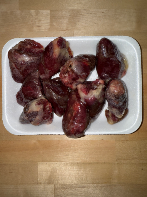Ten Frozen turkey hearts on a tray